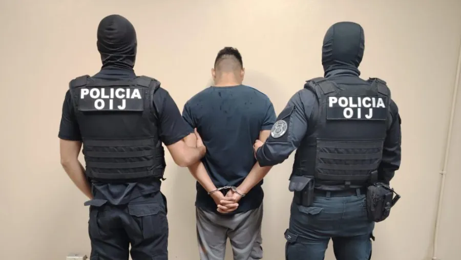 dos oficiales del OIJ deteniendo a presunto criminal